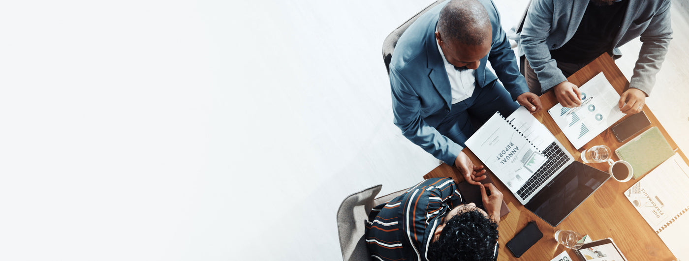 Business meeting with diverse professionals reviewing annual reports and compliance charts, symbolising TechForGood’s Social Procurement and VGPB ICT compliance briefing. Highlights framework analysis, procurement obligations, and evidence pathways for certified social enterprise ICT suppliers in Australia.