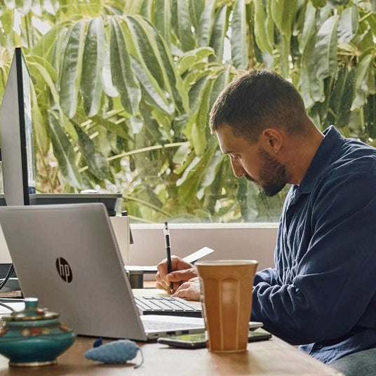 Professional using an HP laptop, supporting responsible procurement and Scope 3 ICT emissions reporting.