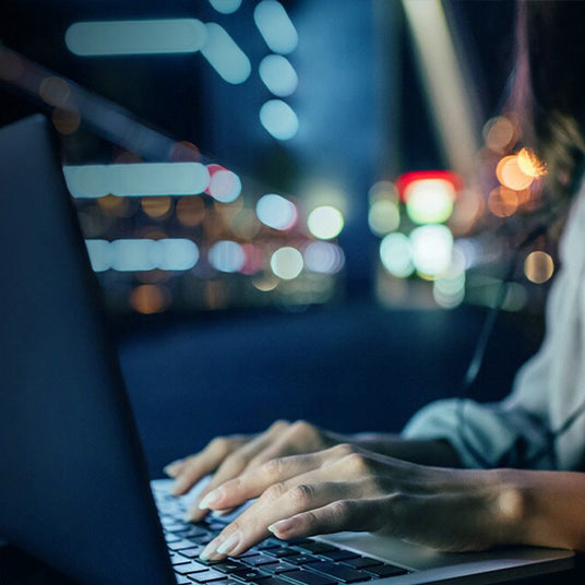 Blurred city lights viewed through a vehicle window, symbolising progress and forward-looking infrastructure.