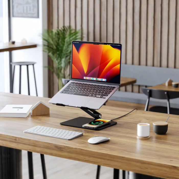 Laptop on a wooden desk with keyboard and mouse in a modern office setting