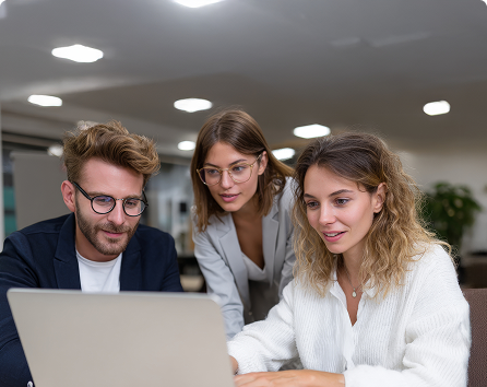 Team collaborating around a laptop with Certified B Corporation badge, representing a B Corp innovator case study where ESG compliance was embedded into every ICT purchase with enhanced reporting from TechForGood.