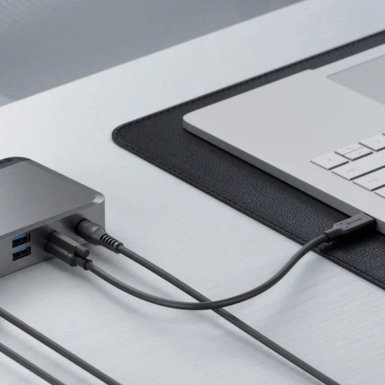 Laptop connected to a USB hub on a desk