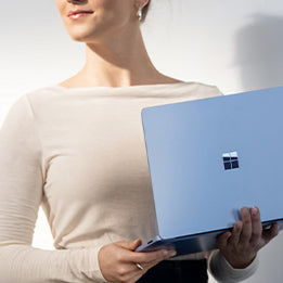 Professional holding Microsoft Surface device as part of enterprise deployment.