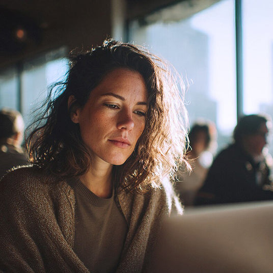 Person working at a laptop in a modern office environment, representing everyday business computing.
