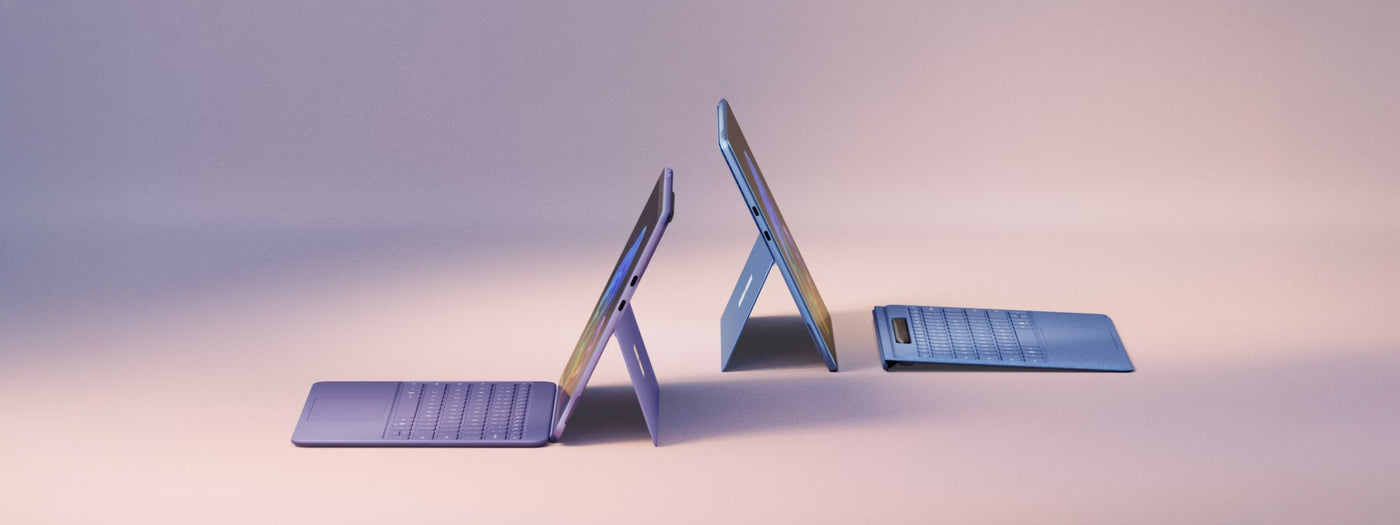 Microsoft Surface devices displayed with kickstands extended, showcasing Surface Pro and Surface Laptop models.