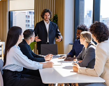 Group of professionals in a meeting with presenter, representing a public institution case study where SPF social procurement quotas were met in 90 days with compliance-ready ESG reporting through TechForGood.